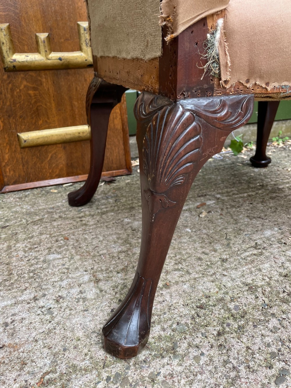 A mid-nineteenth-century carved mahogany Gainsborough armchair upholstered in neutral fabric with carved cabriole legs and claw and ball feet. View X