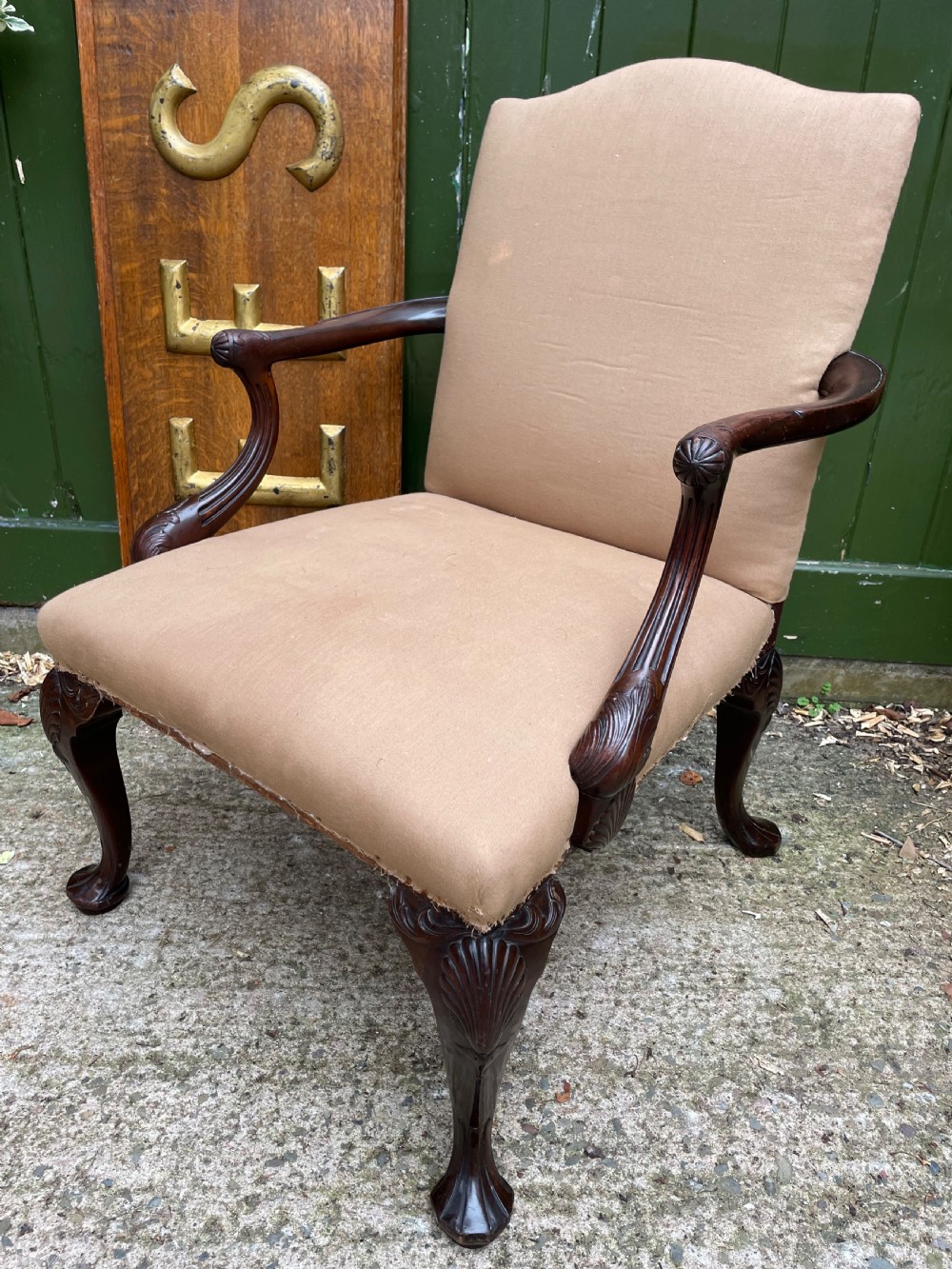 A mid-nineteenth-century carved mahogany Gainsborough armchair upholstered in neutral fabric with carved cabriole legs and claw and ball feet. View XIX