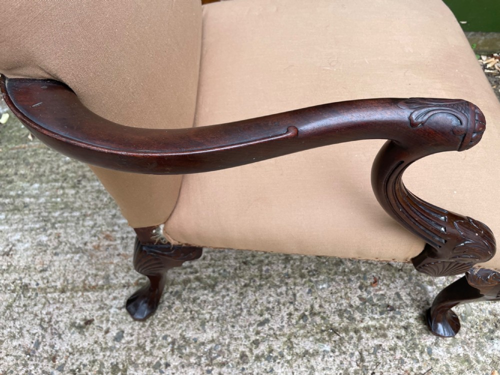 A mid-nineteenth-century carved mahogany Gainsborough armchair upholstered in neutral fabric with carved cabriole legs and claw and ball feet. View XI