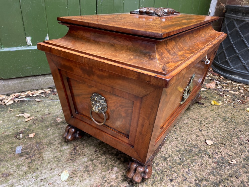 Early C19th Regency period brass-mounted mahogany cellarette or wine-cooler of classical sarcophagus form with a noble armorial . View V