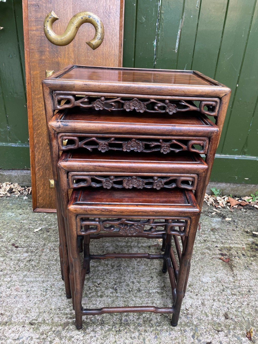 A set of four late nineteenth-century Chinese carved hardwood nesting tables stacked in size order with carved floral aprons. View III