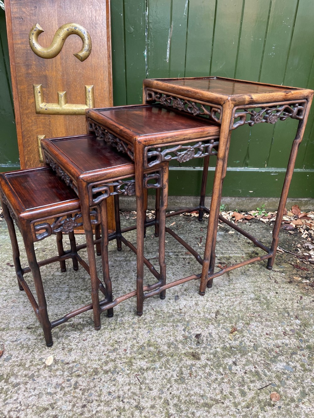 A set of four late nineteenth-century Chinese carved hardwood nesting tables stacked in size order with carved floral aprons. View V