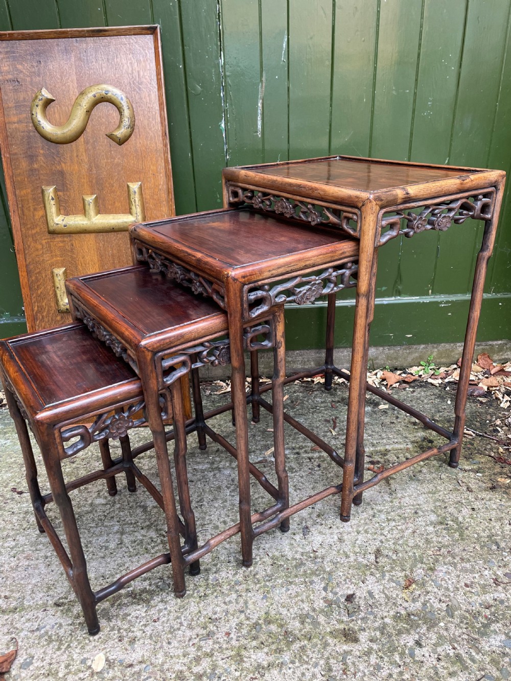 A set of four late nineteenth-century Chinese carved hardwood nesting tables stacked in size order with carved floral aprons. View VI