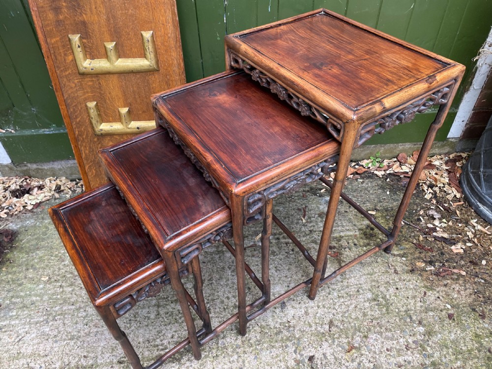 A set of four late nineteenth-century Chinese carved hardwood nesting tables stacked in size order with carved floral aprons. View VII