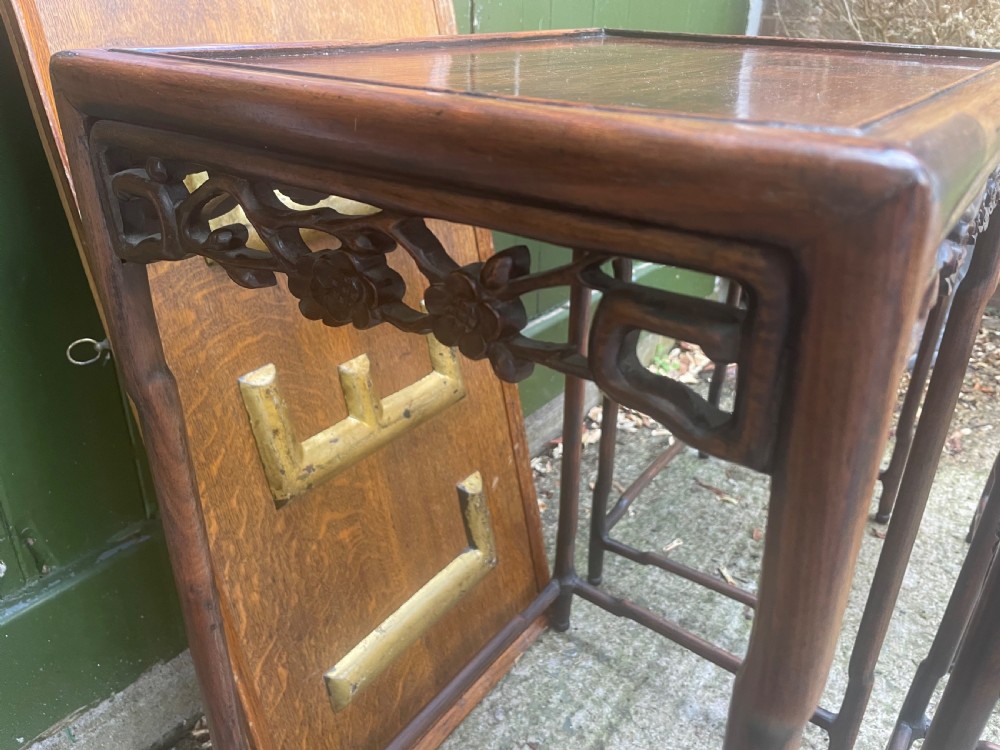 A set of four late nineteenth-century Chinese carved hardwood nesting tables stacked in size order with carved floral aprons. View IX