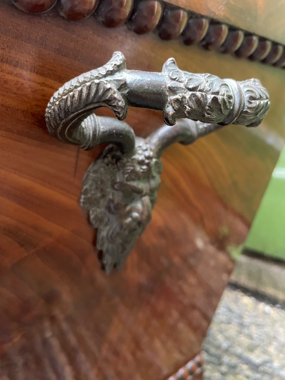 A George IV open mahogany wine cooler of classical sarcophagus form featuring flame mahogany veneer panels and carved bead moulding. View XI