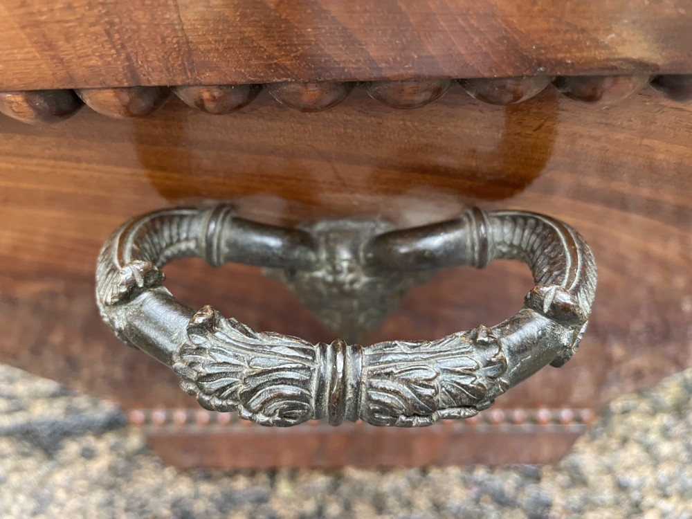 A George IV open mahogany wine cooler of classical sarcophagus form featuring flame mahogany veneer panels and carved bead moulding. View XXI