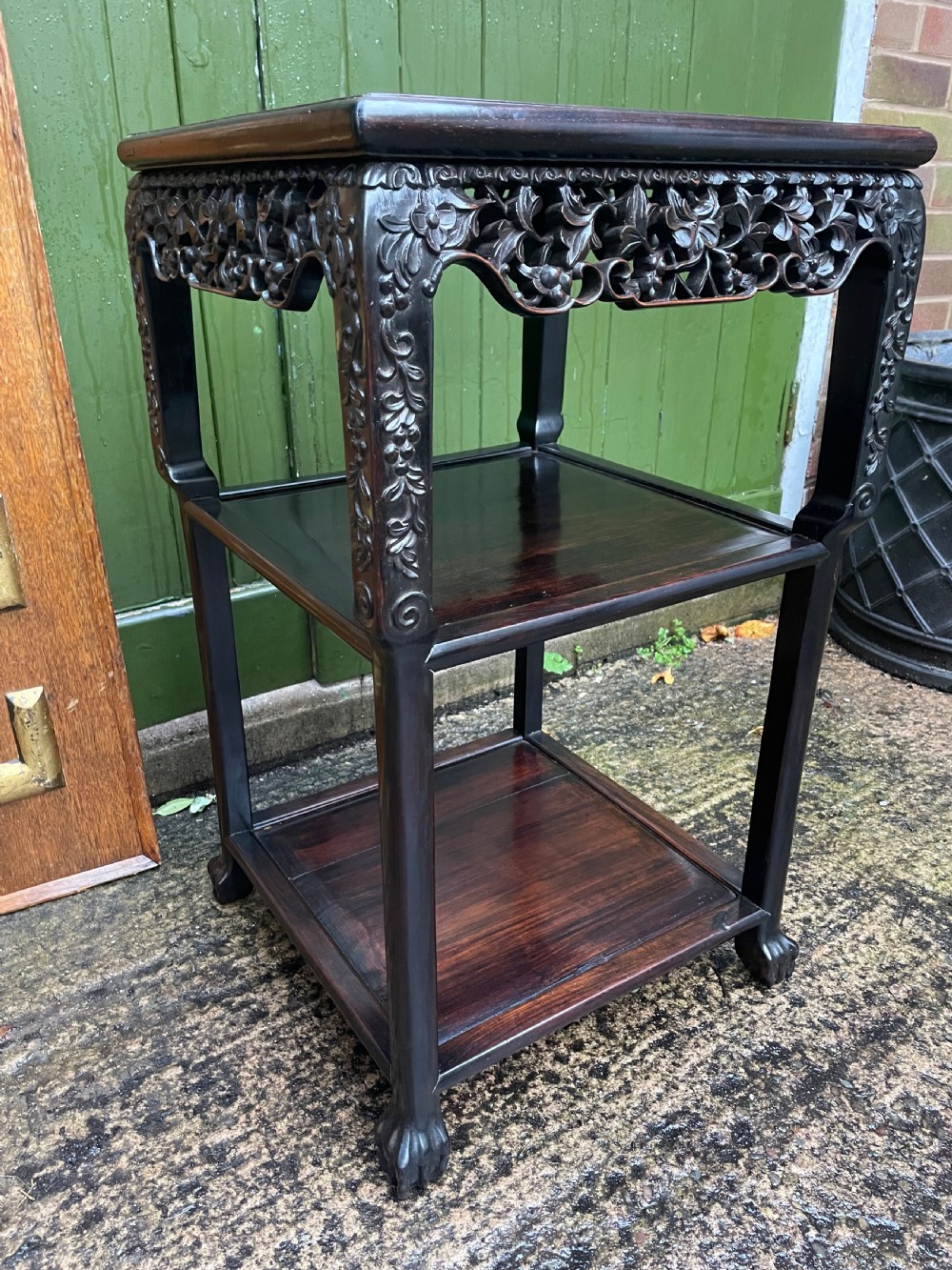 A late nineteenth-century Chinese square dark hardwood two-tier side table featuring intricately carved floral openwork aprons and lower shelf tiers. View II