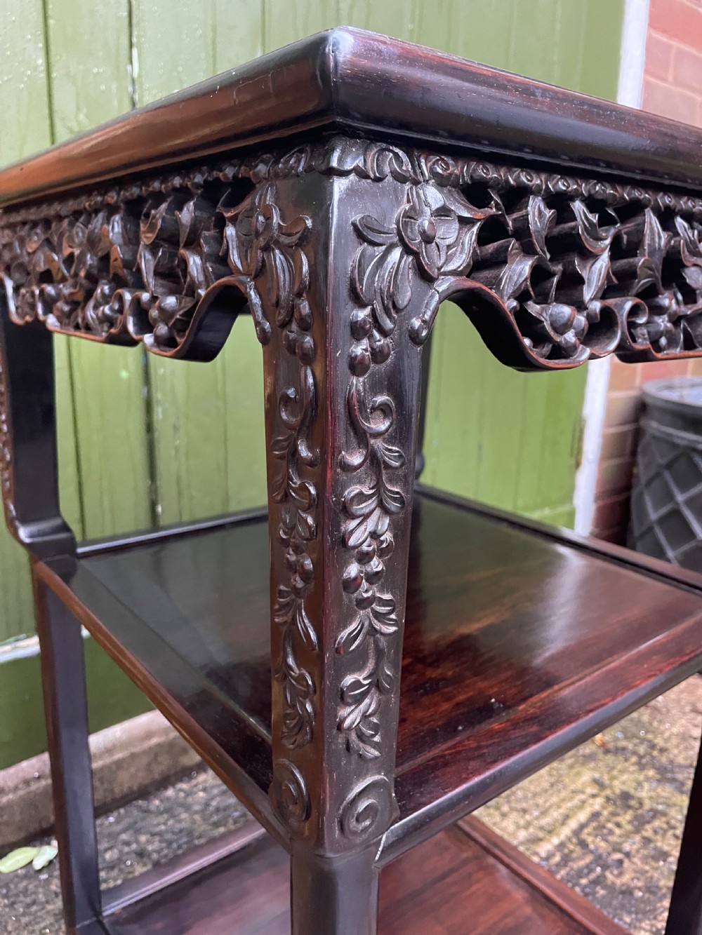A late nineteenth-century Chinese square dark hardwood two-tier side table featuring intricately carved floral openwork aprons and lower shelf tiers. View IV