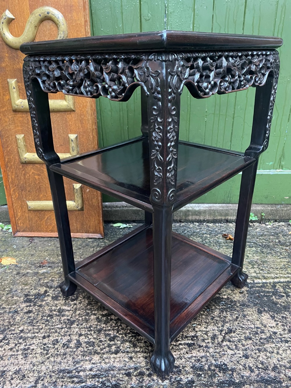 A late nineteenth-century Chinese square dark hardwood two-tier side table featuring intricately carved floral openwork aprons and lower shelf tiers. View VI