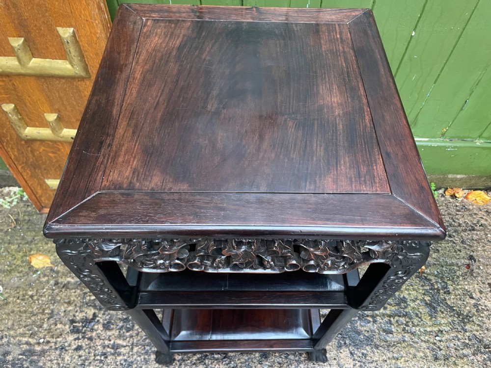 A late nineteenth-century Chinese square dark hardwood two-tier side table featuring intricately carved floral openwork aprons and lower shelf tiers. View XIII