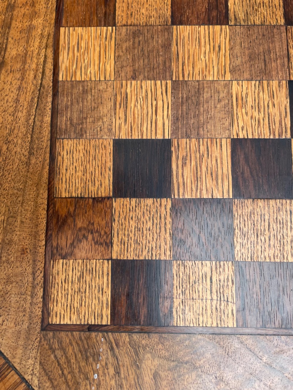 An early nineteenth-century Regency octagonal rosewood games table with a chequerboard inlaid top, brass mounts, and a tripod base. View VII