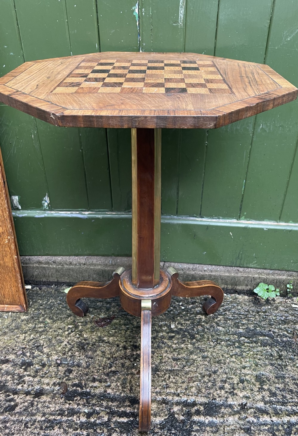 An early nineteenth-century Regency octagonal rosewood games table with a chequerboard inlaid top, brass mounts, and a tripod base. View X