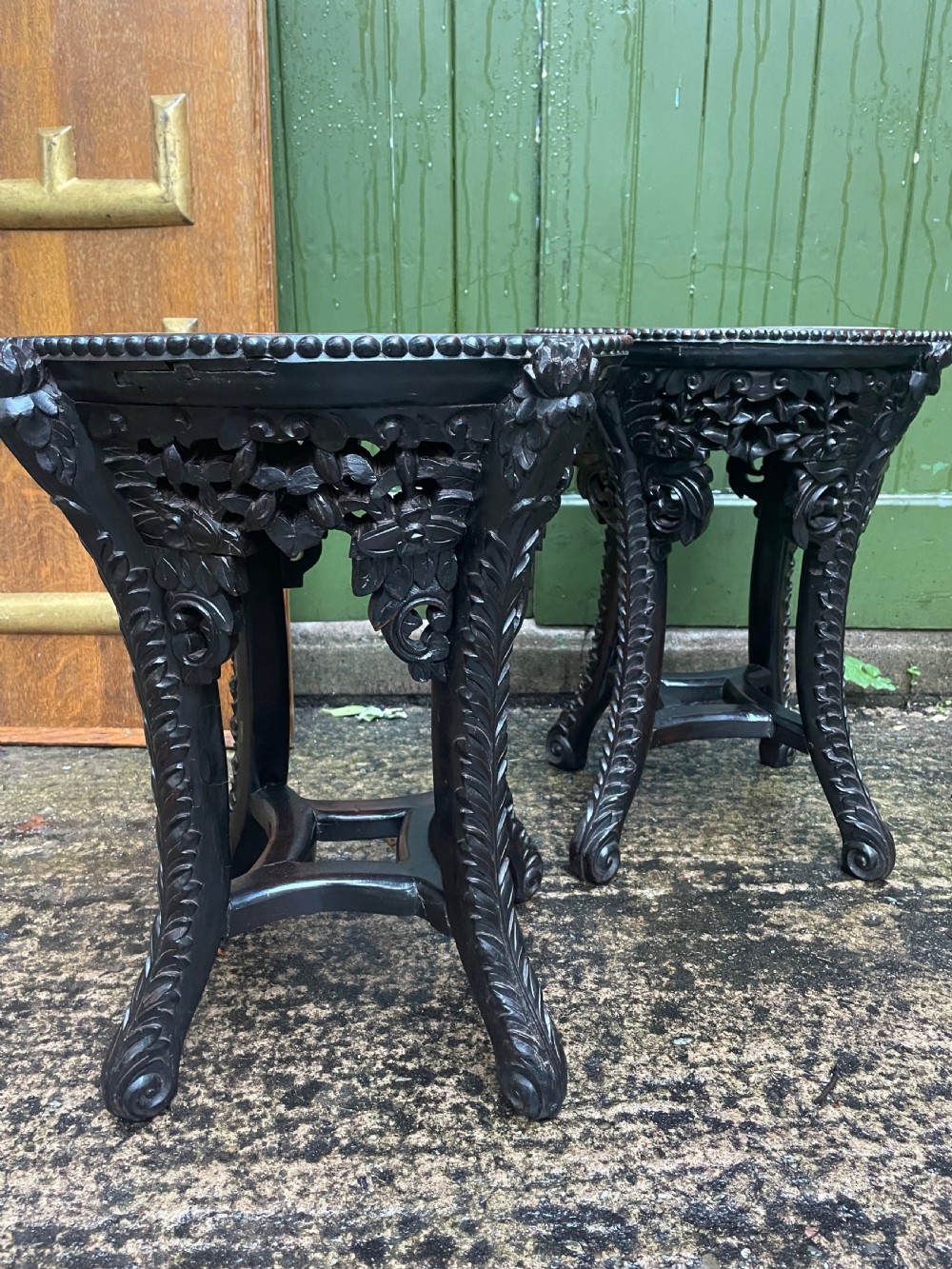 A pair of circular late nineteenth-century Chinese hardwood stands featuring inset pinkish rouge marble tops and intricately carved aprons and legs. View VI