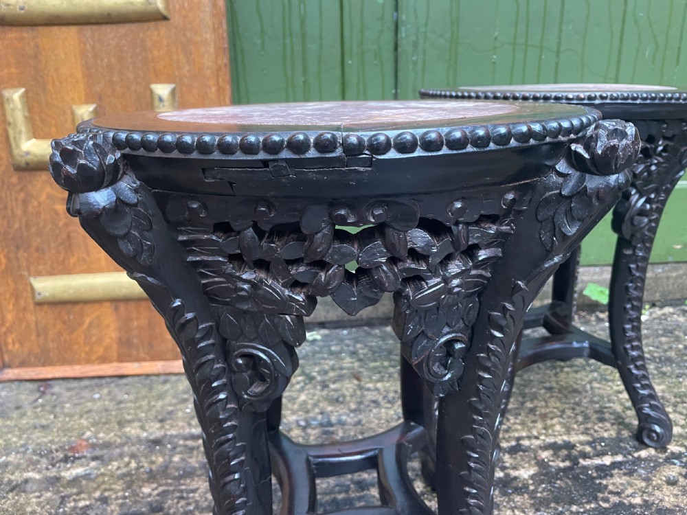 A pair of circular late nineteenth-century Chinese hardwood stands featuring inset pinkish rouge marble tops and intricately carved aprons and legs. View VIII