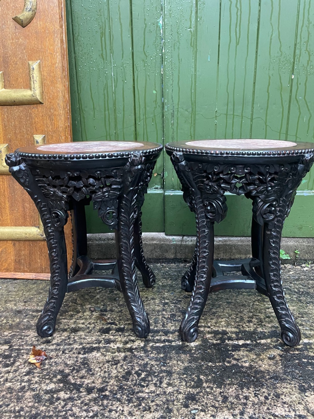 A pair of circular late nineteenth-century Chinese hardwood stands featuring inset pinkish rouge marble tops and intricately carved aprons and legs. View XII