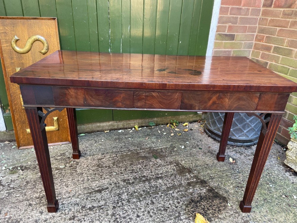 A late 18th-century George III mahogany pier table featuring fluted legs, carved corner brackets, and a rectangular polished top. View II
