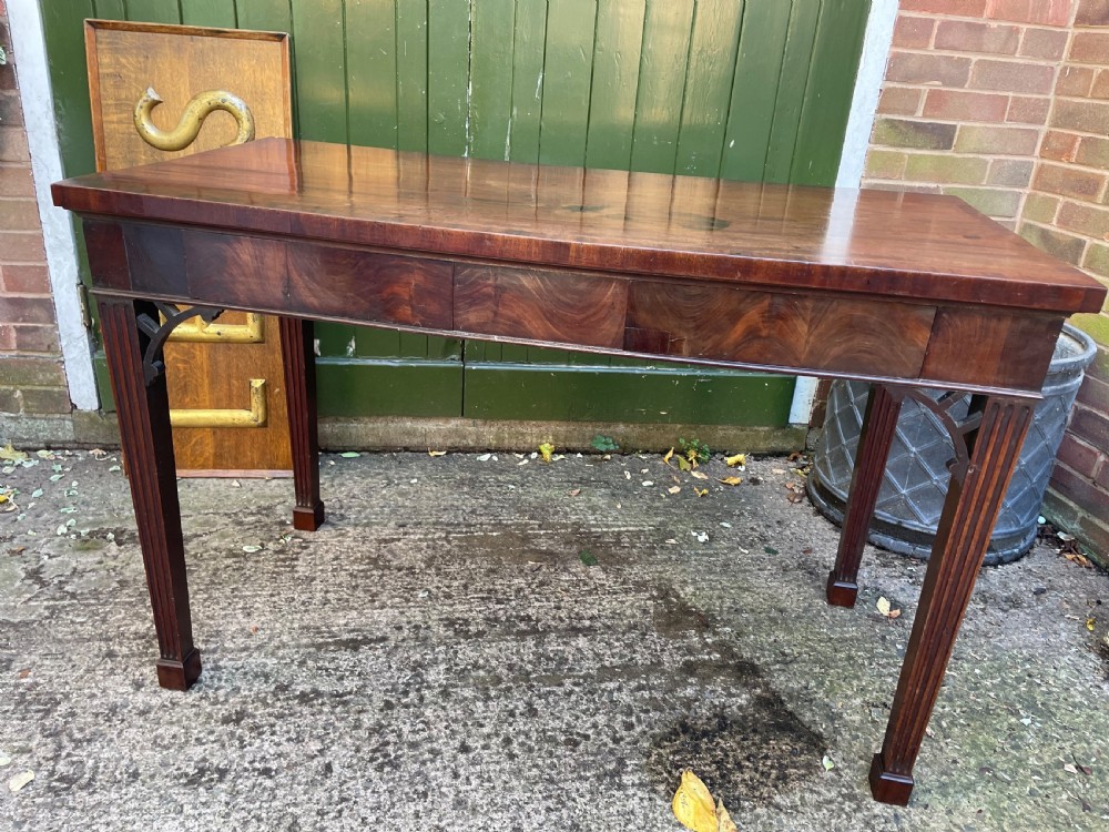 A late 18th-century George III mahogany pier table featuring fluted legs, carved corner brackets, and a rectangular polished top. View V