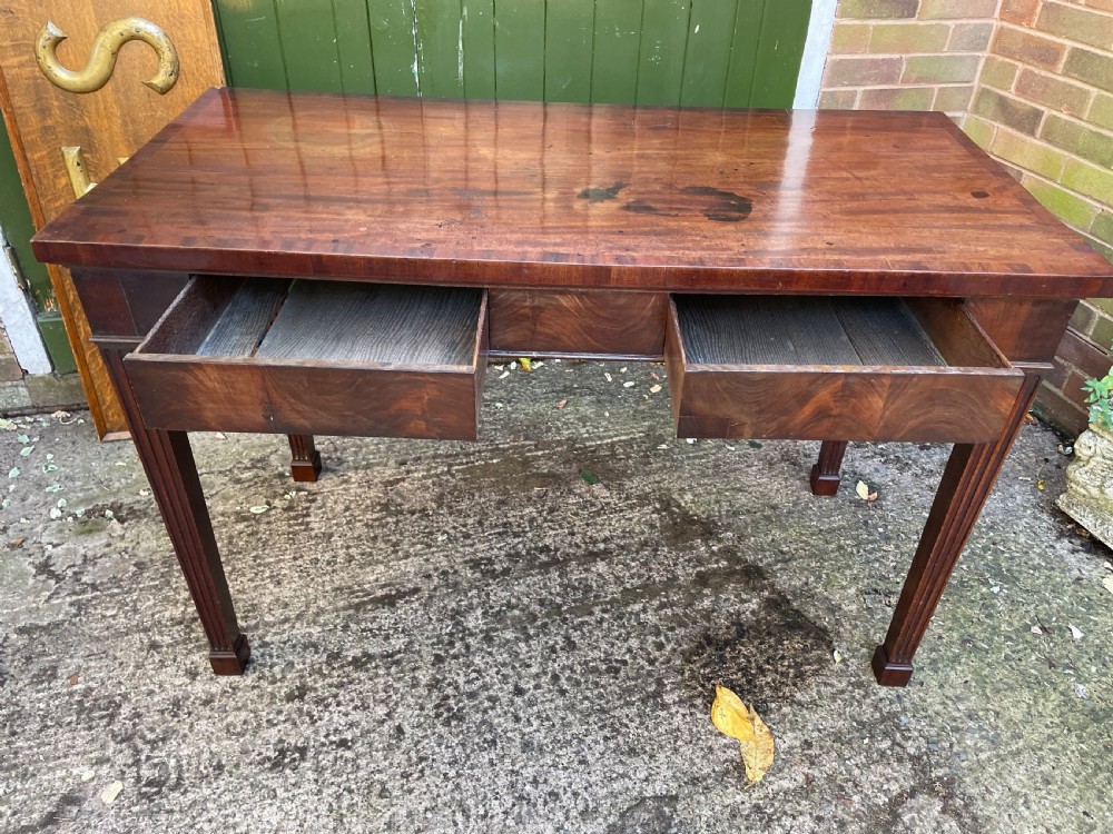 A late 18th-century George III mahogany pier table featuring fluted legs, carved corner brackets, and a rectangular polished top. View VII