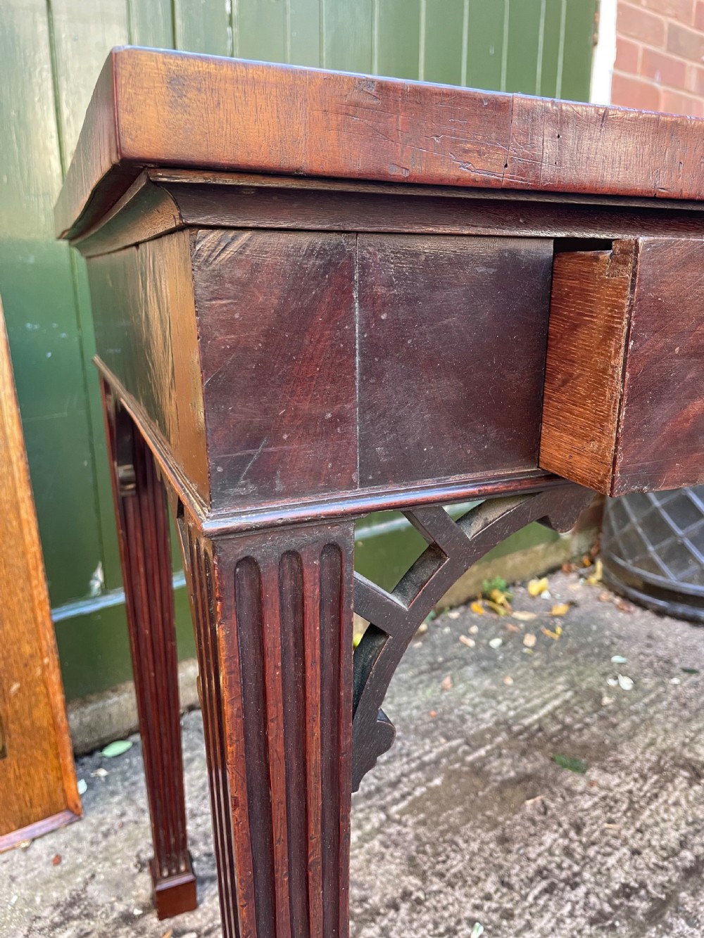 A late 18th-century George III mahogany pier table featuring fluted legs, carved corner brackets, and a rectangular polished top. View IX