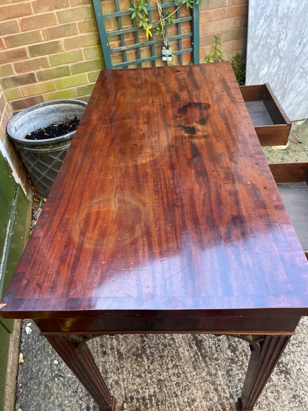 A late 18th-century George III mahogany pier table featuring fluted legs, carved corner brackets, and a rectangular polished top. View X