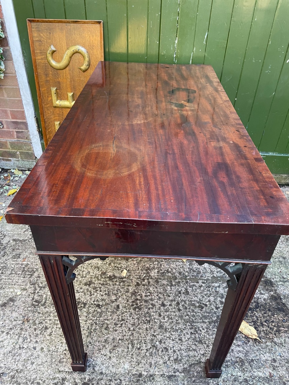 A late 18th-century George III mahogany pier table featuring fluted legs, carved corner brackets, and a rectangular polished top. View XV