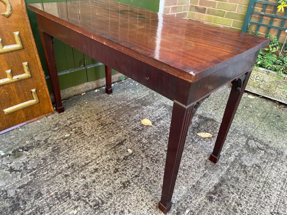 A late 18th-century George III mahogany pier table featuring fluted legs, carved corner brackets, and a rectangular polished top. View XVI