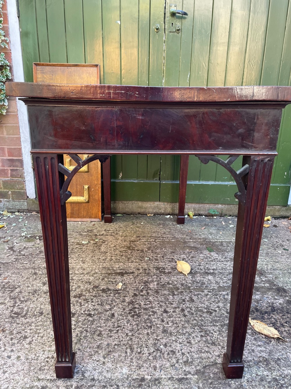A late 18th-century George III mahogany pier table featuring fluted legs, carved corner brackets, and a rectangular polished top. View XVIII