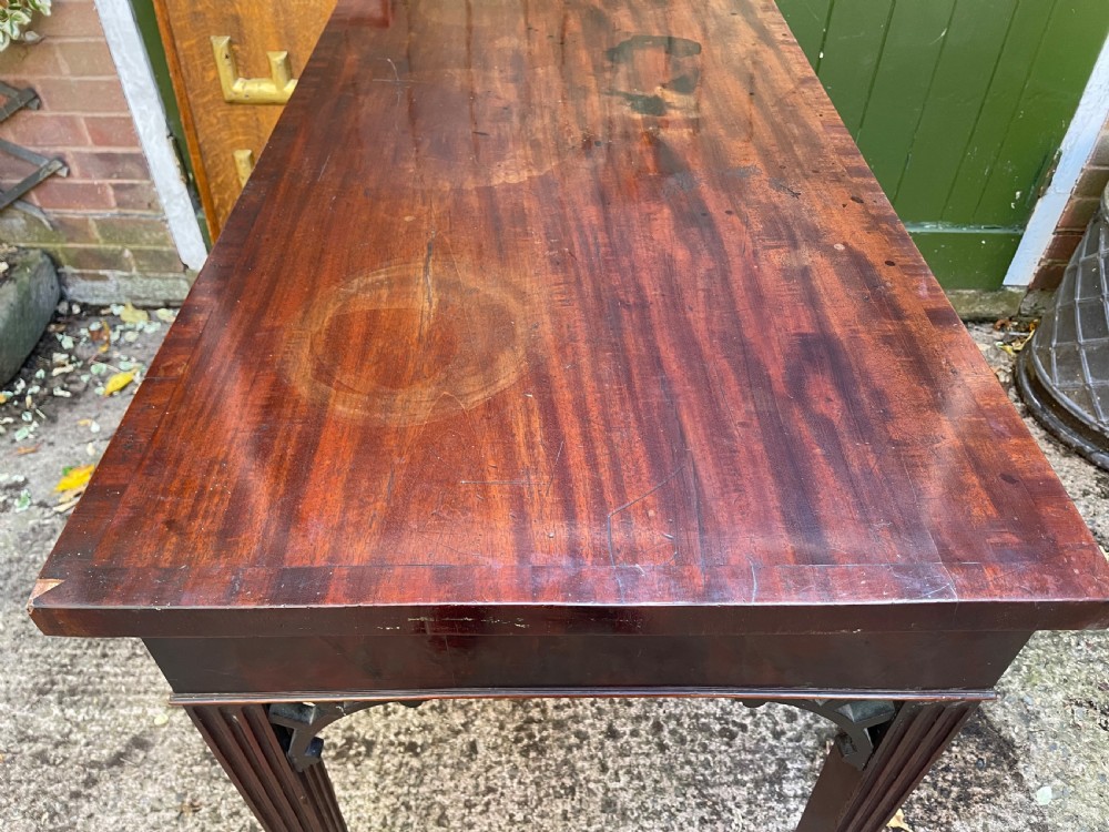 A late 18th-century George III mahogany pier table featuring fluted legs, carved corner brackets, and a rectangular polished top. View XIX