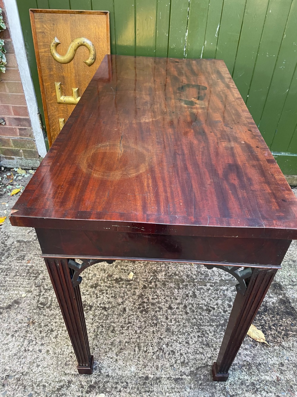 A late 18th-century George III mahogany pier table featuring fluted legs, carved corner brackets, and a rectangular polished top. View XX