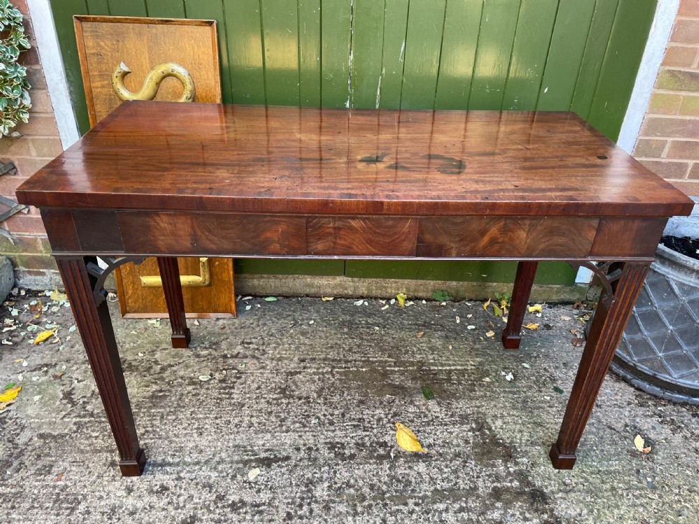 A late 18th-century George III mahogany pier table featuring fluted legs, carved corner brackets, and a rectangular polished top. View XXVI