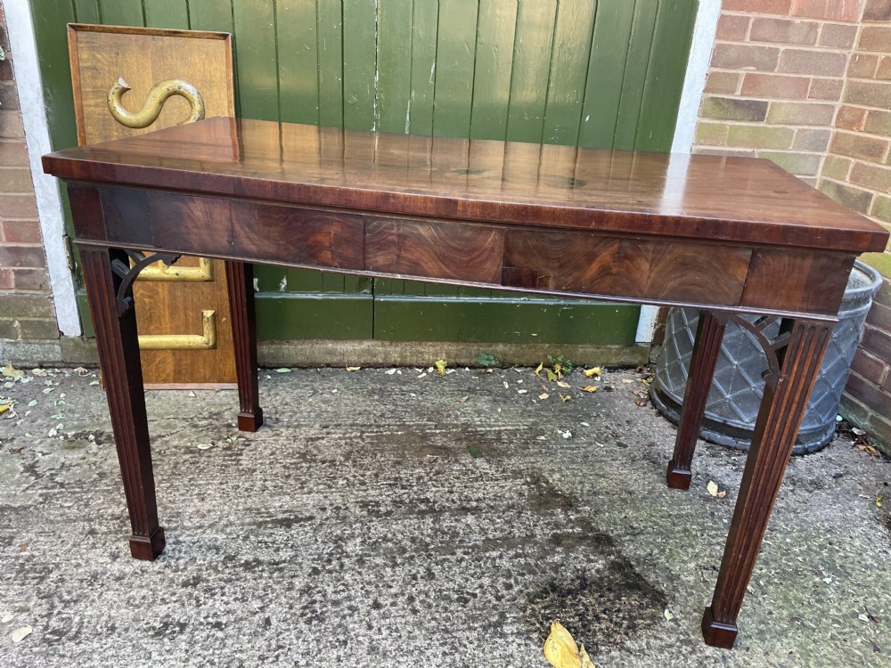 A late 18th-century George III mahogany pier table featuring fluted legs, carved corner brackets, and a rectangular polished top. View XXVII