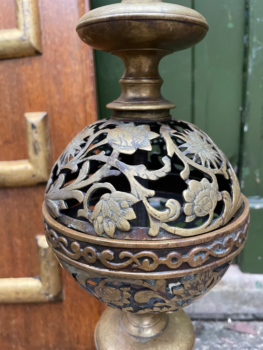 A pair of 19th-century Baroque revival brass andirons featuring mascaron face motifs, openwork spherical finials, and scrolled bases. View IV