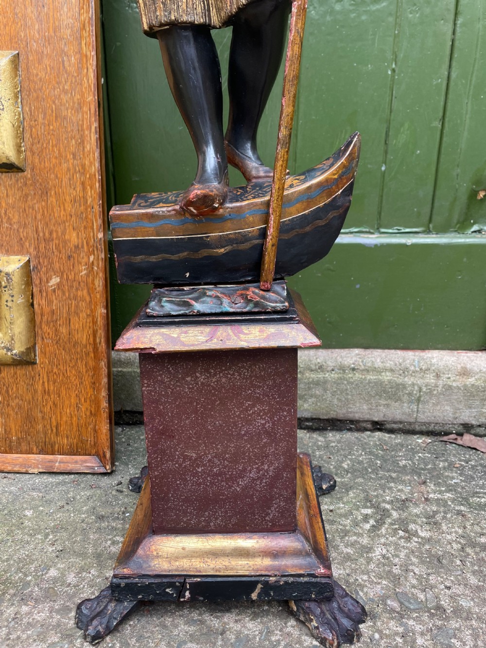 A late 19th-century Italian Venetian carved wood polychrome figure of a gondolier standing on a boat base atop a plinth, holding an oar and raised tray. View IV