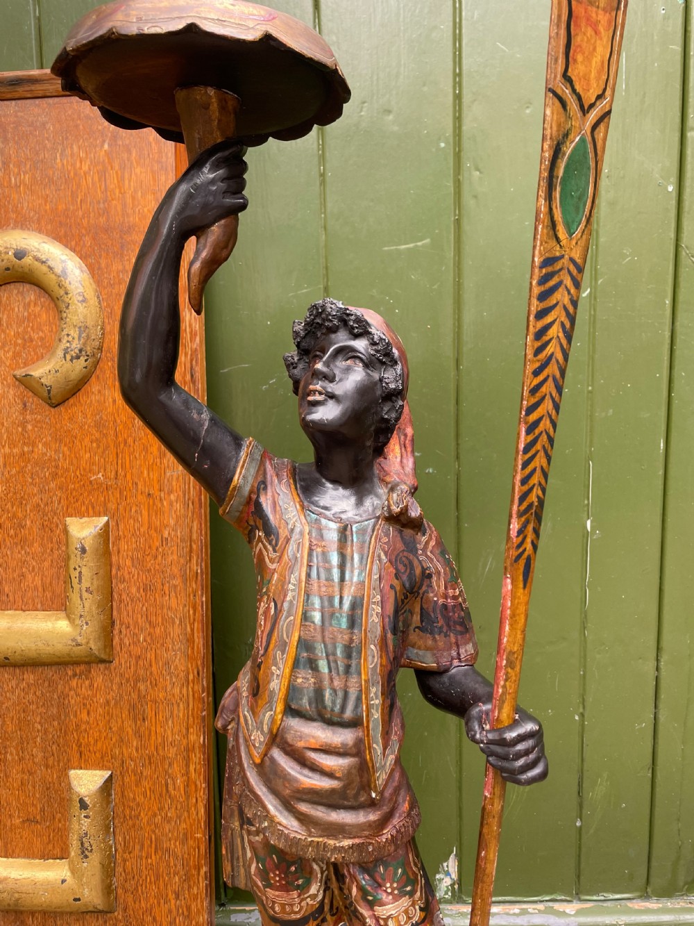 A late 19th-century Italian Venetian carved wood polychrome figure of a gondolier standing on a boat base atop a plinth, holding an oar and raised tray. View VI