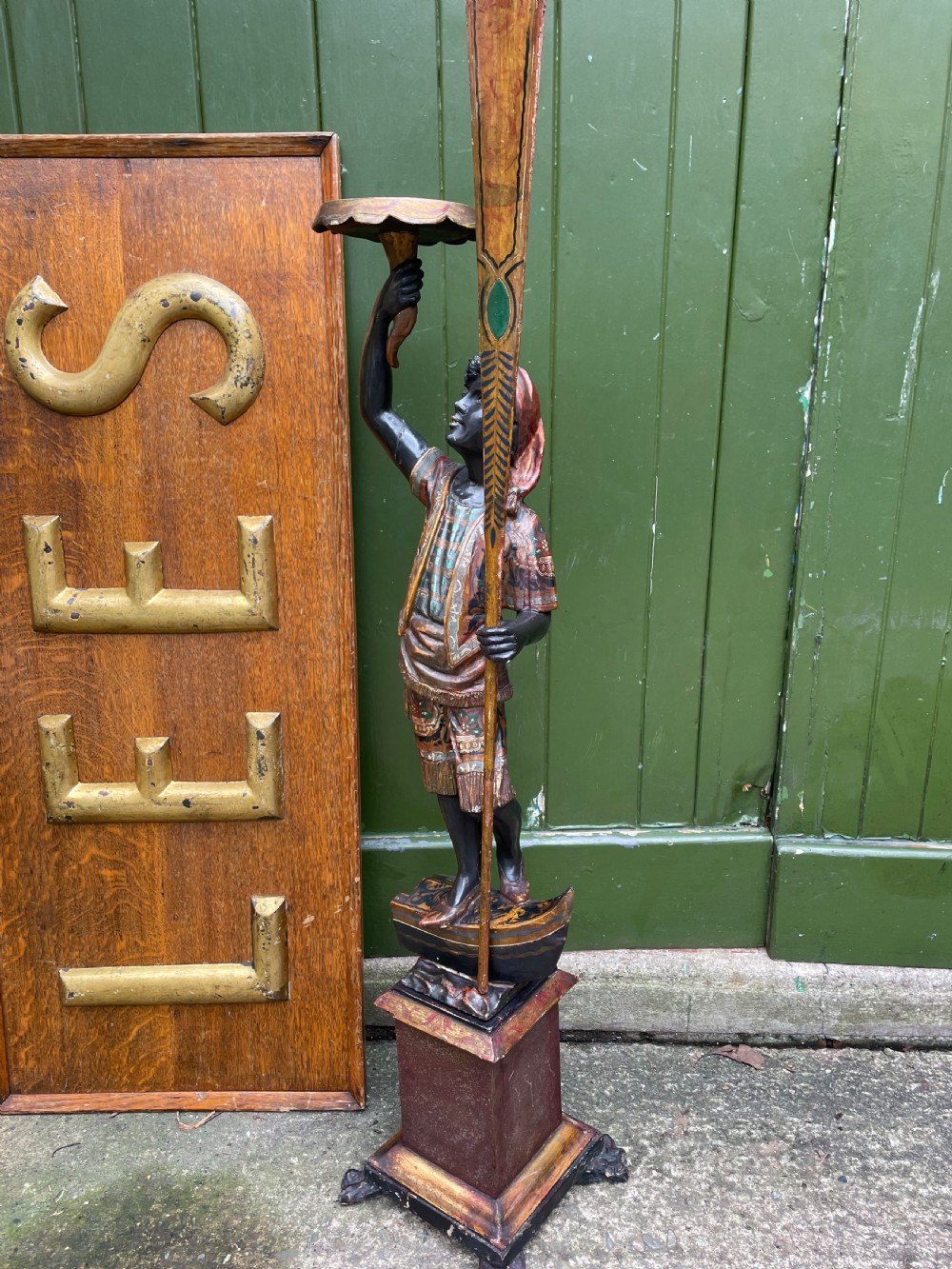 A late 19th-century Italian Venetian carved wood polychrome figure of a gondolier standing on a boat base atop a plinth, holding an oar and raised tray. View VIII