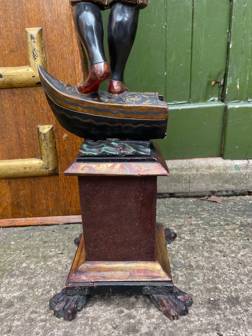 A late 19th-century Italian Venetian carved wood polychrome figure of a gondolier standing on a boat base atop a plinth, holding an oar and raised tray. View XIV