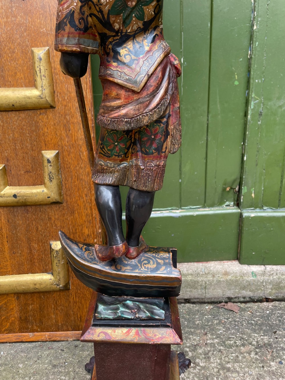 A late 19th-century Italian Venetian carved wood polychrome figure of a gondolier standing on a boat base atop a plinth, holding an oar and raised tray. View XV