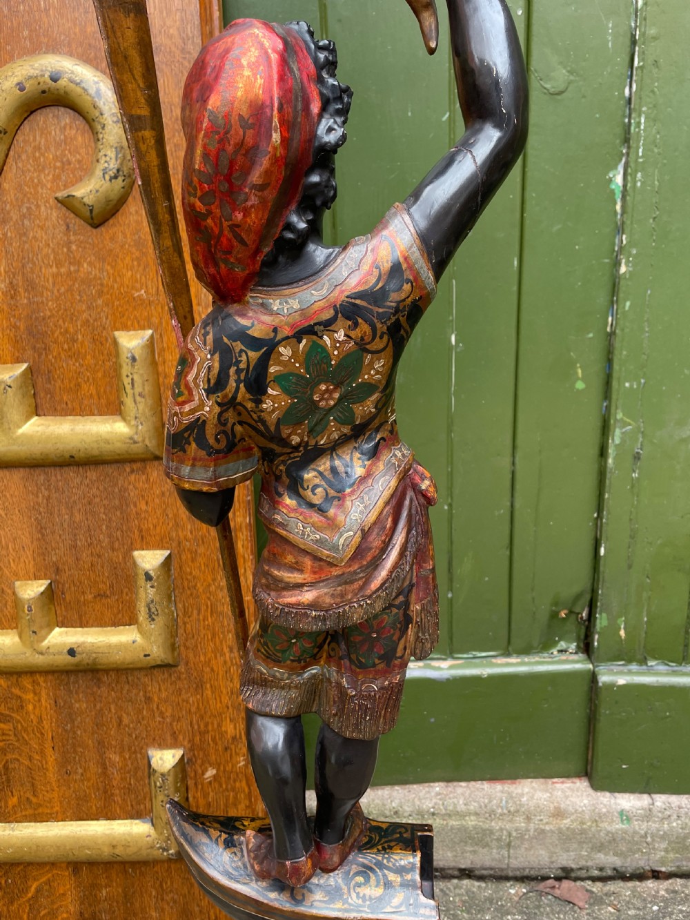 A late 19th-century Italian Venetian carved wood polychrome figure of a gondolier standing on a boat base atop a plinth, holding an oar and raised tray. View XVII