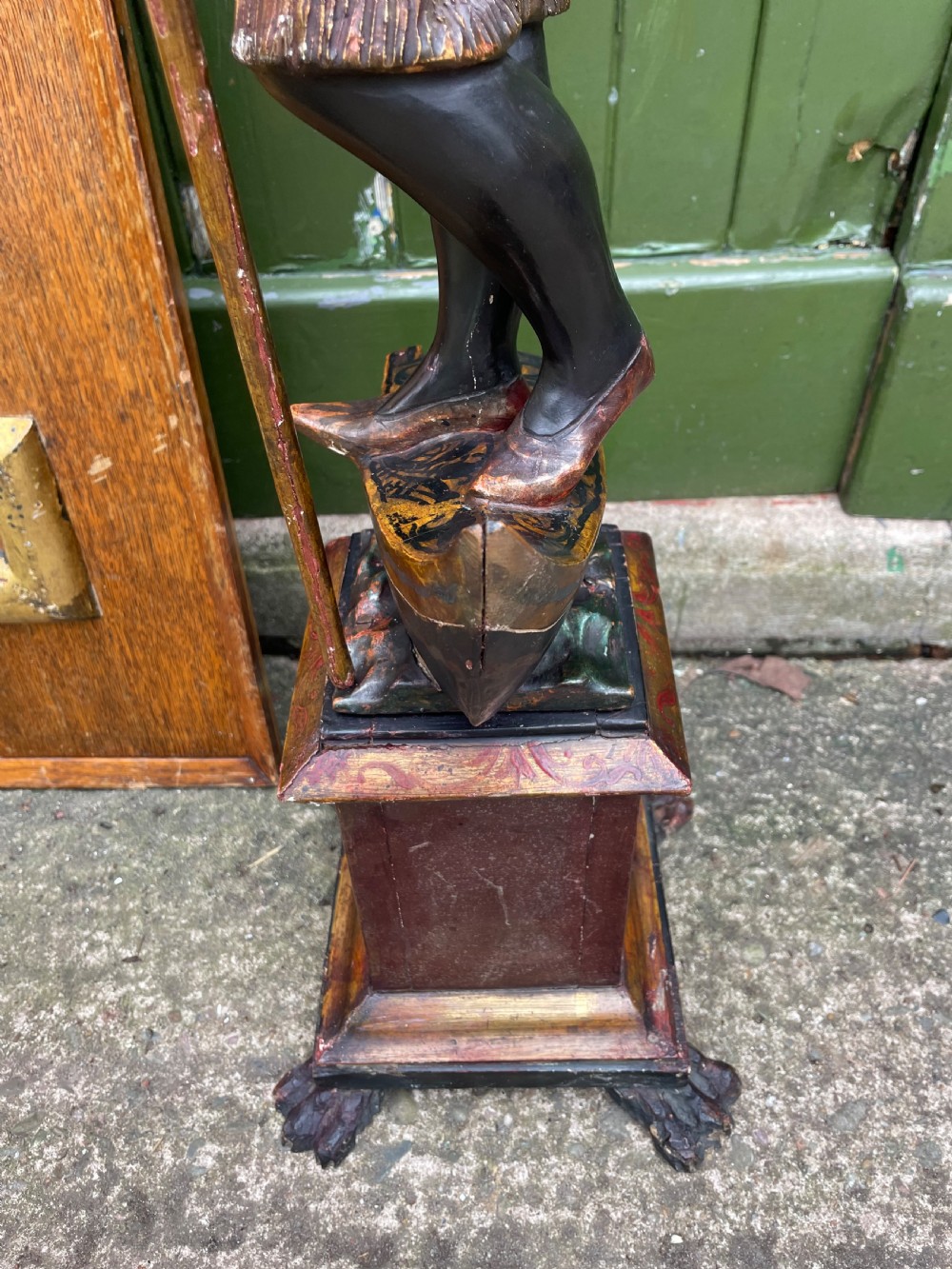 A late 19th-century Italian Venetian carved wood polychrome figure of a gondolier standing on a boat base atop a plinth, holding an oar and raised tray. View XX