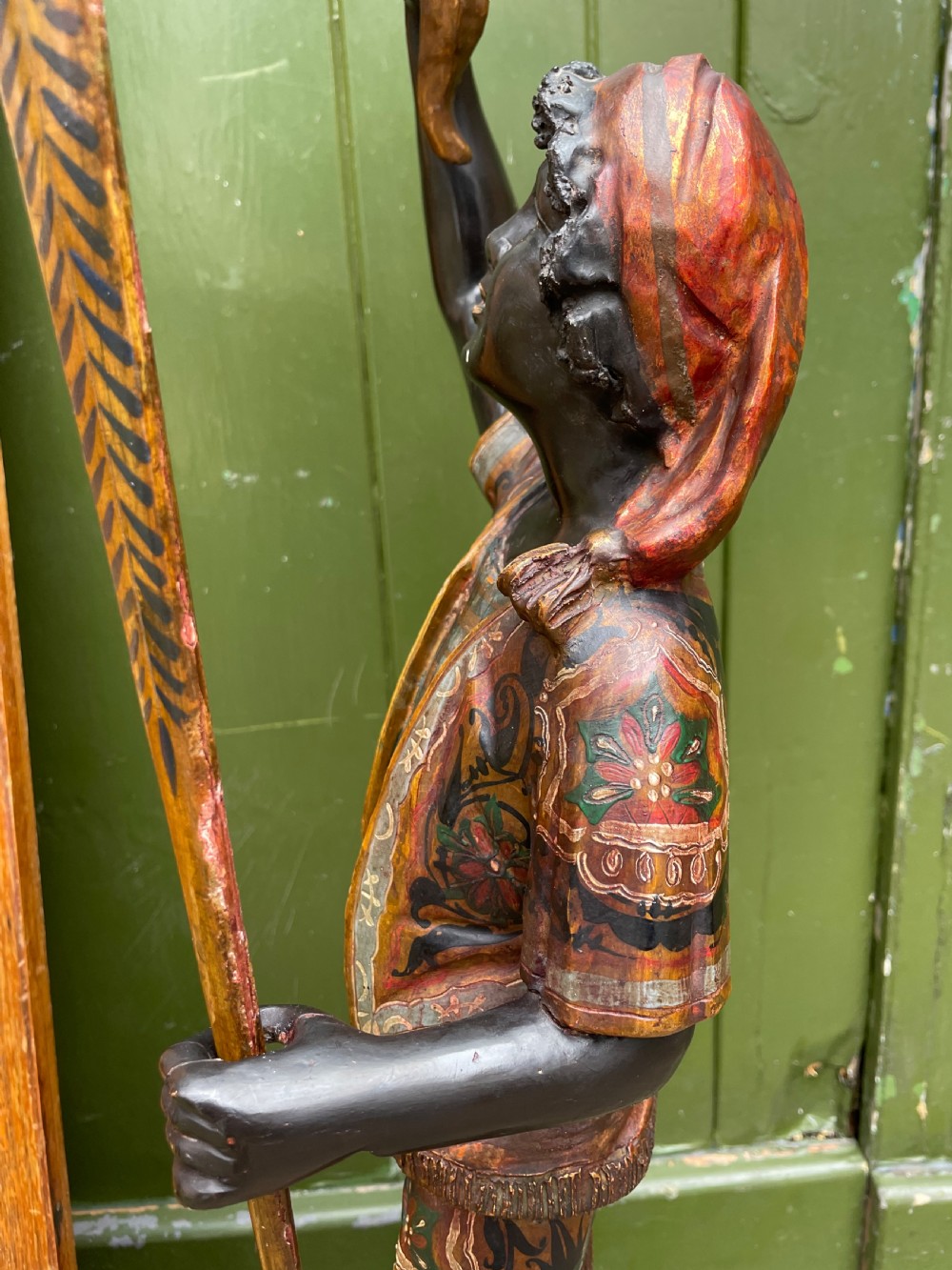 A late 19th-century Italian Venetian carved wood polychrome figure of a gondolier standing on a boat base atop a plinth, holding an oar and raised tray. View XXI