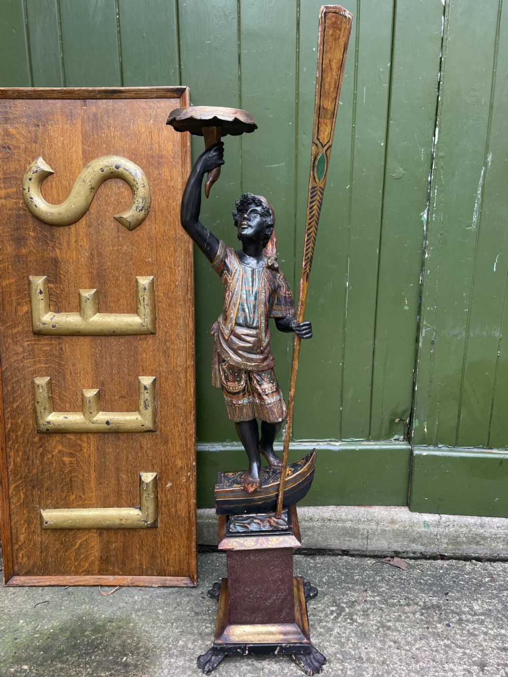 A late 19th-century Italian Venetian carved wood polychrome figure of a gondolier standing on a boat base atop a plinth, holding an oar and raised tray. View XXII