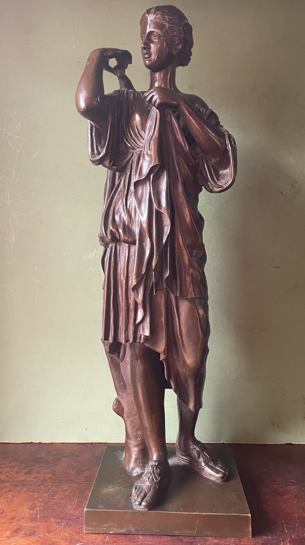 A 19th-century dark bronze sculpture depicting the classical figure of Diane de Gabii adjusting her draped robe.