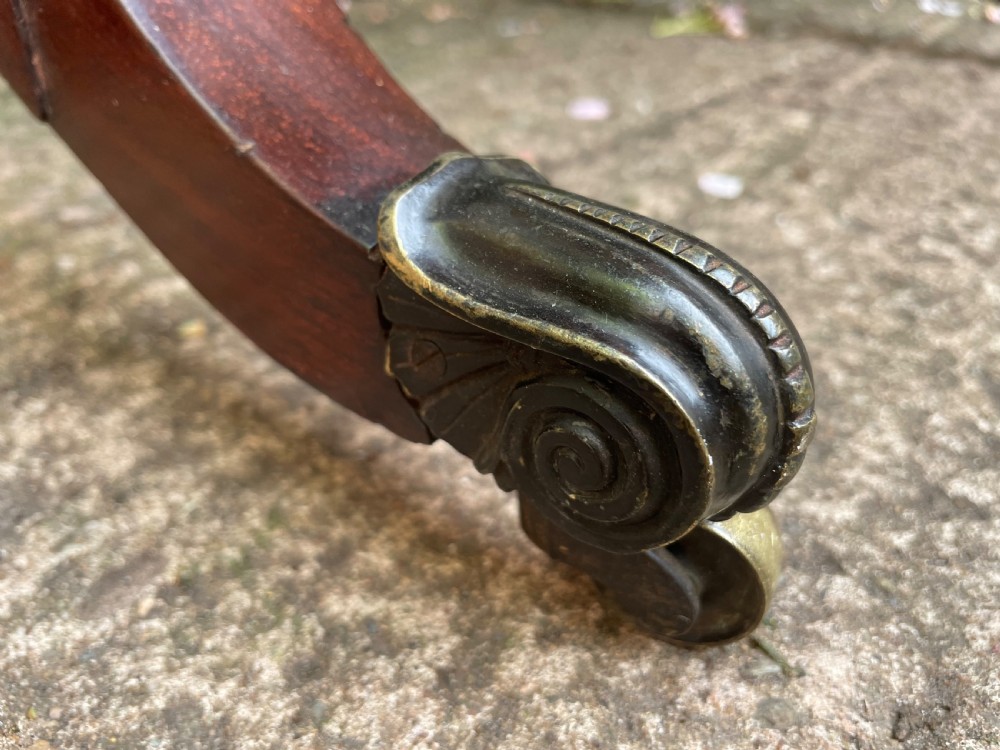An early 19th-century George IV figured rosewood work table featuring a smooth polished top, single drawer, fabric work basket, turned twin-column supports, and brass castors. View XII
