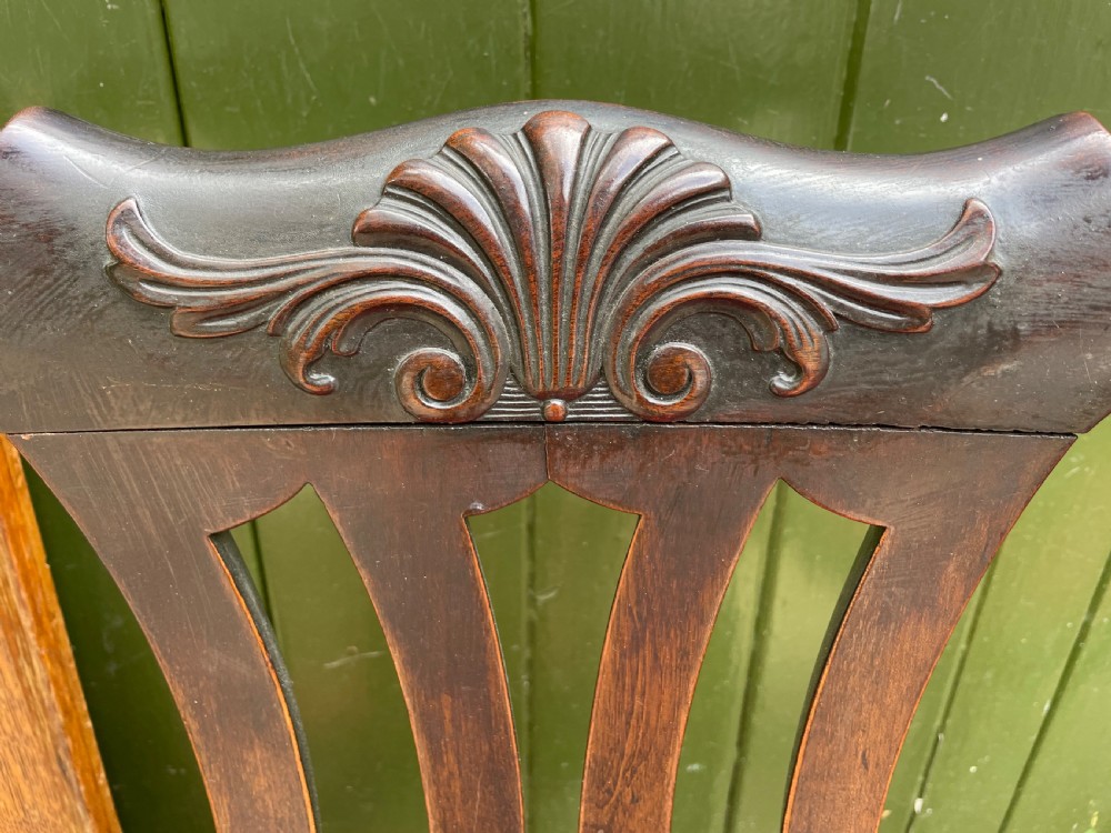 A pair of 19th-century mahogany open armchairs featuring carved shell cresting, pierced vertical splats, patterned red velvet seats, and cabriole legs with claw and ball feet. View IV
