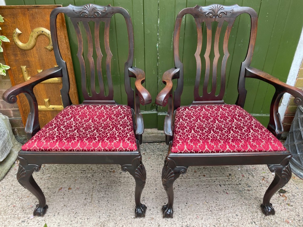 A pair of 19th-century mahogany open armchairs featuring carved shell cresting, pierced vertical splats, patterned red velvet seats, and cabriole legs with claw and ball feet. View XII