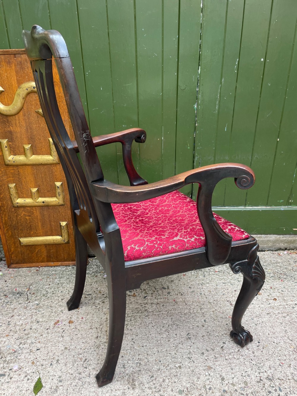 A pair of 19th-century mahogany open armchairs featuring carved shell cresting, pierced vertical splats, patterned red velvet seats, and cabriole legs with claw and ball feet. View XVIII