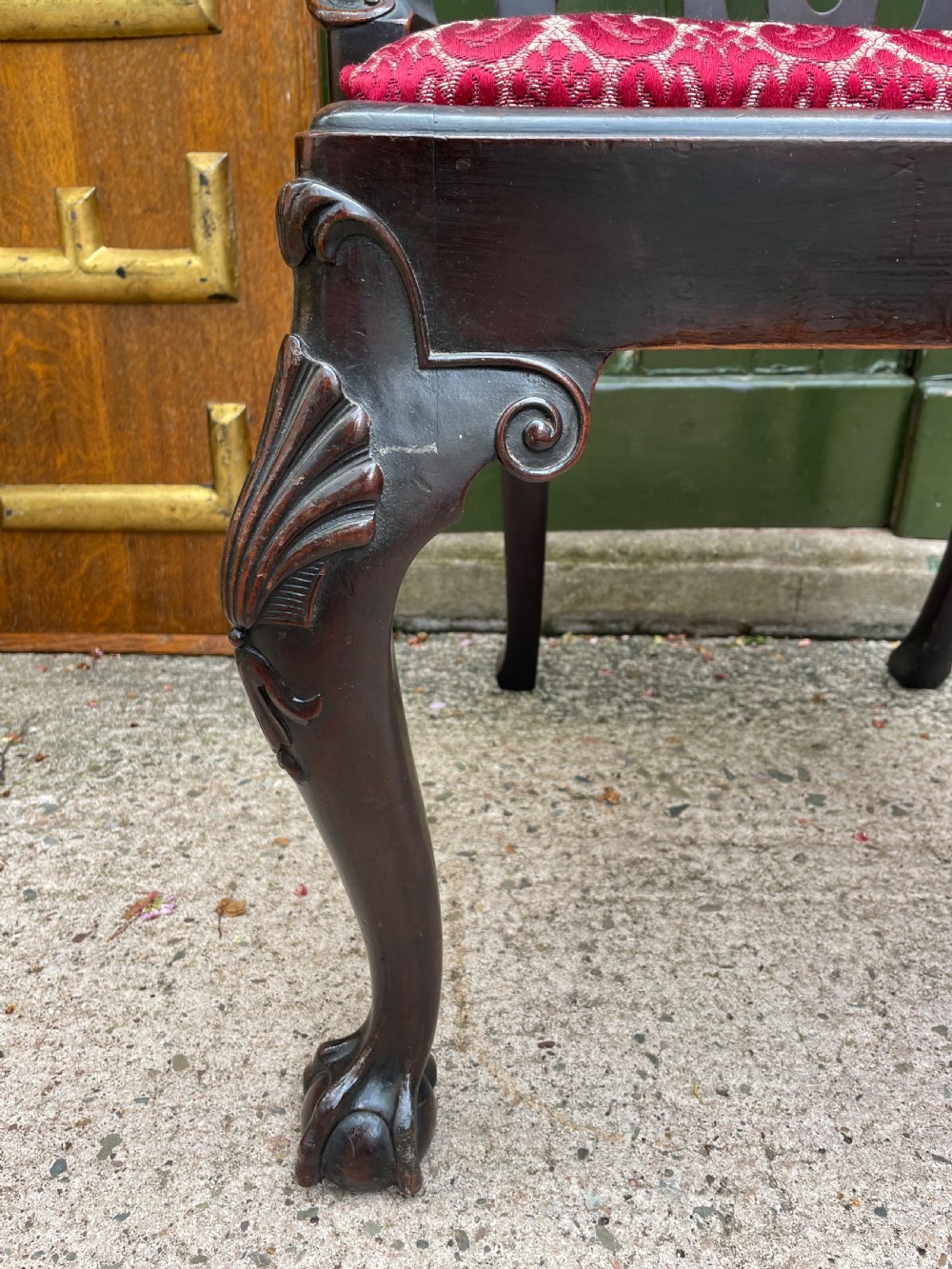 A pair of 19th-century mahogany open armchairs featuring carved shell cresting, pierced vertical splats, patterned red velvet seats, and cabriole legs with claw and ball feet. View XX