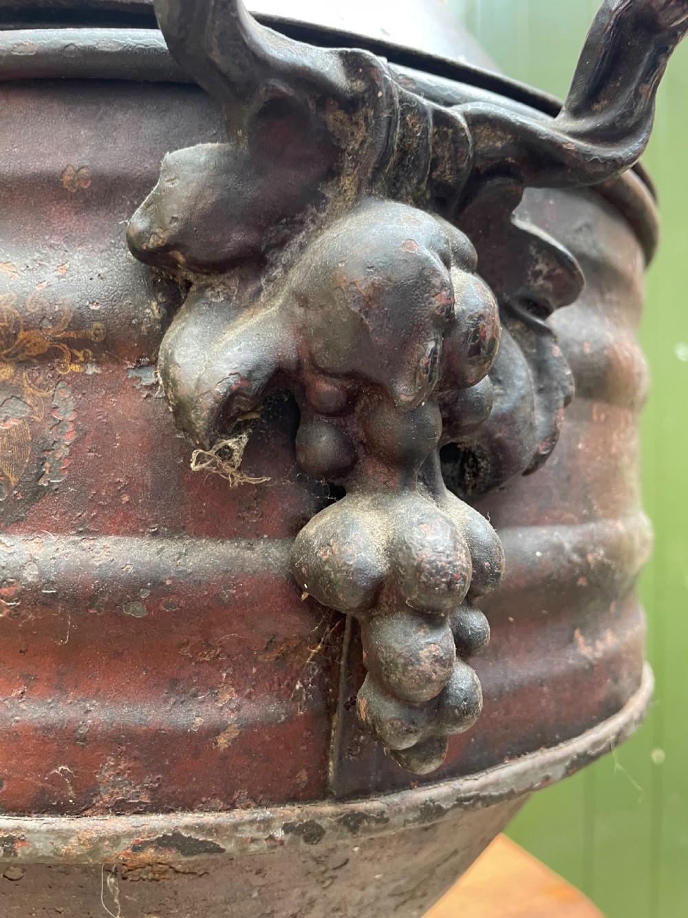 An early nineteenth-century round japanned tinware wine cooler with a domed lid, pedestal base, twin loop handles, and faded painted floral motifs. View VI