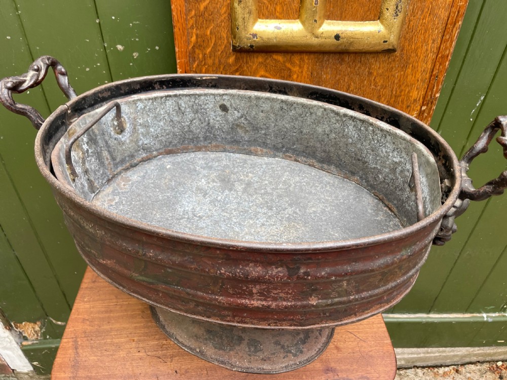 An early nineteenth-century round japanned tinware wine cooler with a domed lid, pedestal base, twin loop handles, and faded painted floral motifs. View X